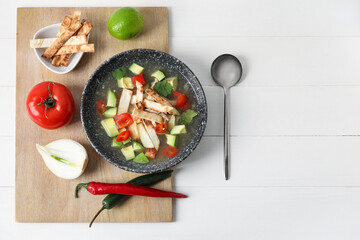 Composition with tasty Sopa de Lima soup on light wooden background