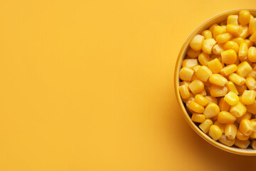 Bowl of corn kernels on color background