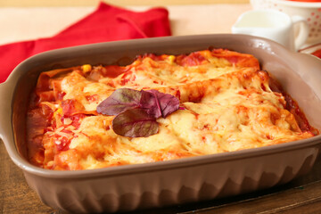 Baking dish with tasty tomato lasagna on table