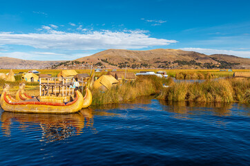 Uros floating islands with totora reed boat, Titicaca Lake, Peru.