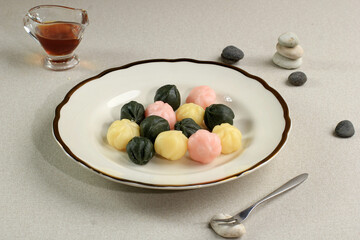 Colorful Songpyeon Kkultteok (Rice Cake with Honey FIlling) in a Wooden Dish. Songpyeon is a Korean Traditional Food Eaten during New Year's Day or Korean Thanks Giving Day.