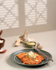 Korean Pancake Kimchi Jeon. Pan Fried Egg, Kimchi, and Flour. Served with Soy Sauce on Rattan Plate with Copy Space for Text