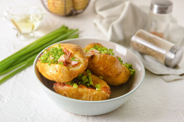 Bowl with baked potato on table