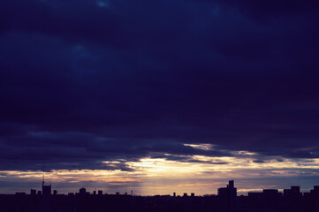 兵庫県神戸市東灘区の高層マンションの上層階からの夜明け。大阪生駒山から太陽が昇り、あたりはオレンジ色に染まり、ビル群がシルエットで浮かぶ。