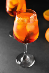 Glass of tasty aperol spritz cocktail on dark background
