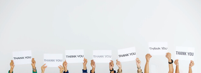Studio shot of variety fonts thank you letters paper sign holden above head by group of unrecognizable unidentified faceless officer staff showing appreciation to customers on white background