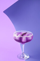 Glass of fresh cocktail with lavender on color background