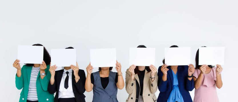 Studio shot of incognito unidentified unrecognizable faceless group of female office staff in business wears stand hold blank empty paper sign cover face for advertisement text on white background