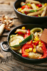 Frying pans with different vegetables on wooden background, closeup