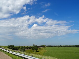 Altocumulus castellanus clouds over a green field of hay. Kansas Flint Hills. 