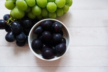 grapes in a bowl on white wooden background. Fresh grapes, Fresh food.
