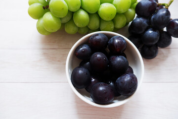 grapes in a bowl on white wooden background. Fresh grapes, Fresh food.