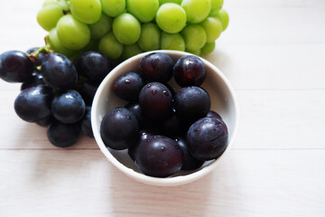 grapes in a bowl on white wooden background. Fresh grapes, Fresh food. 