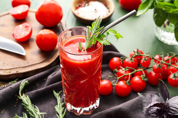 Glass of tasty tomato juice on color wooden background