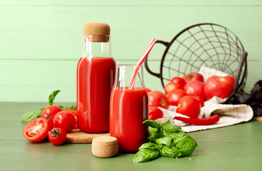 Bottles of tasty tomato juice on color wooden background