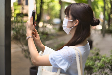 ビジネス　女性　スマートフォン（マスク）