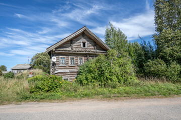 Fototapeta na wymiar Wooden houses in the Russian village. Street in the village.
