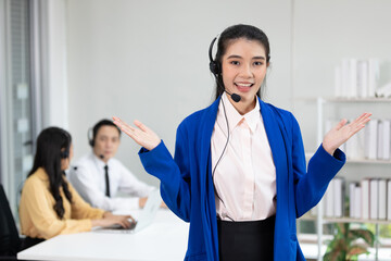 portrait smiling woman operator wearing headphones for work and showing pose at call center service