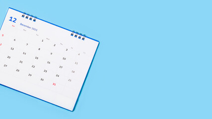 white desk calendar on blue background, planning concept