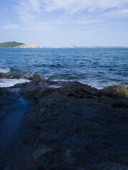 Rocky shore with island on the horizon.