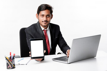 technology concept : Young indian businessman showing tablet scr