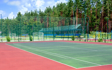 Sports ground on the outskirts of the city in a wooded area. View of the tennis court, fitness...