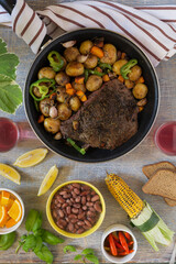 Traditional lunch American cooking grilled steak and various vegetables, top view