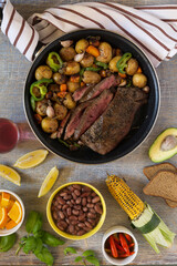 Traditional lunch American cooking grilled steak and various vegetables, top view
