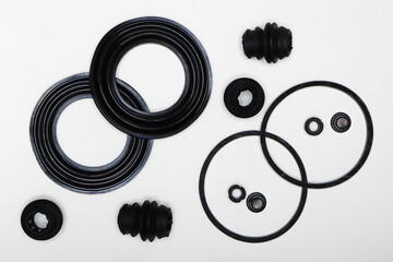 Rubber gaskets, rings, oil seals, machine repair parts. A set of spare parts for servicing the braking system of a vehicle. Details on white background, copy space available.