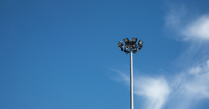 Spotlight On An Aluminum Pole With A Background In The Blue Sky.