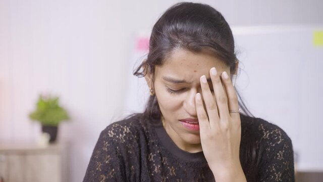Close up head shot frustrated sad crying young indian woman - concept of emotional, mental or work stress