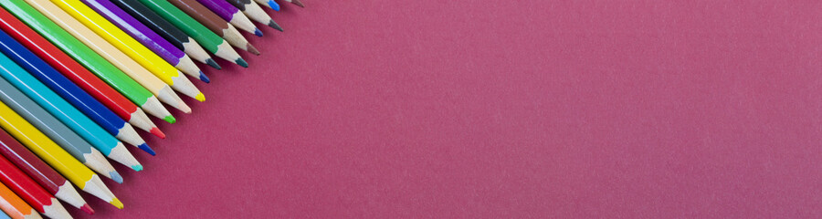 Fototapeta premium colored pencils on a red background close-up. drawing tool. banner for placement on the site