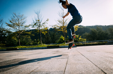 Asian woman skateboarder skateboarding in modern city