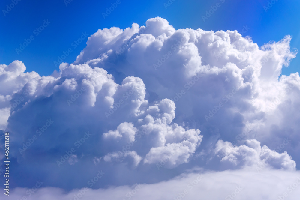 Wall mural a large white cloud against the blue sky, a view from the plane window. space for copying text