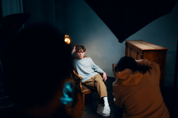 guy sitting on a chair next to the piano posing photo