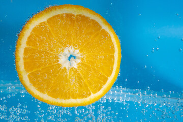 orange fruit in the water close-up macro. Refreshing grapefruit drink, cocktail. Slow motion