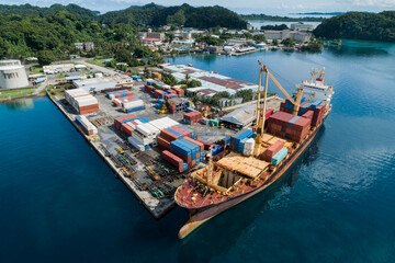 Container ship unloads cargo at dock in Micronesia