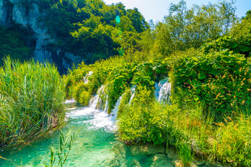 View of waterfall at Plitvice lakes, Croatia. Panoramic view of fresh nature, blue water and green trees.