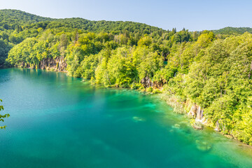 Fototapeta na wymiar View of waterfall at Plitvice lakes, Croatia. Panoramic view of fresh nature, blue water and green trees.