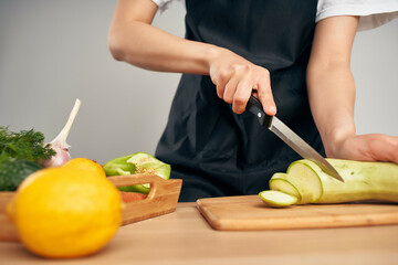 Woman in black apron slicing vegetables kitchen cooking food