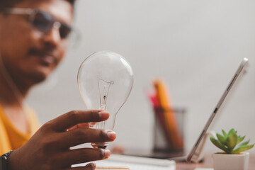 Businessman holding a light bulb showing imaginary graphics of business network technology innovation.
