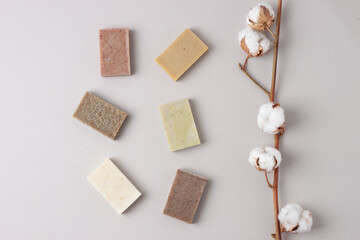 Soap with flowers on pastel grey background. Flat lay, copy space.