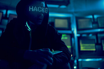 Cyber hacker breaks into databases to obtain information using a computer.
