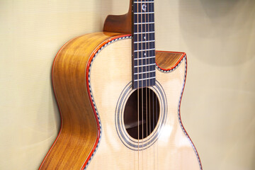 View of acoustic guitar body close up, strings and fretboard, musical instrument design