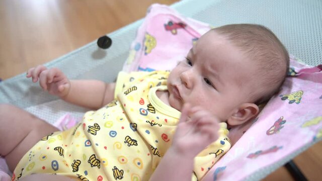 Newborn mischievous in a baby rocking chair