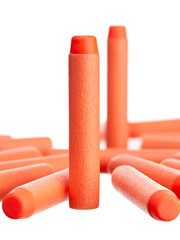 Close-up of a scattering of orange plastic toy cartridges for pneumatic weapons with a soft tip, isolated on a white background. - 452119418