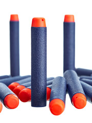 Close-up of a scattering of toy plastic cartridges for pneumatic weapons in blue with an orange tip, isolated on a white background. - 452119490