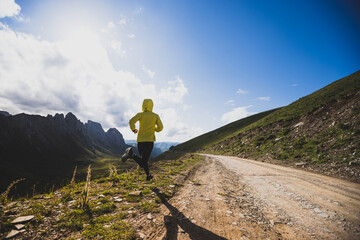 Obraz premium Woman runner running at mountain top