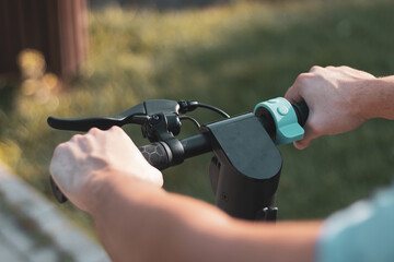 
a detail of hands driving an electric scooter.