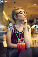 woman with short hairstyle in a cafe cocktail rest pensive look
